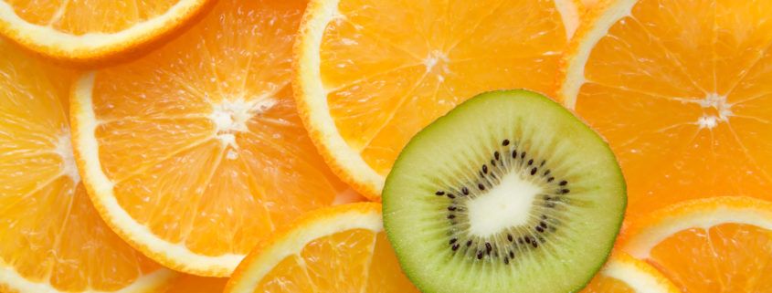 Image of fresh oranges with the kiwi that stands out from the rest