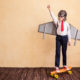 Success of young businessman with toy paper wings.